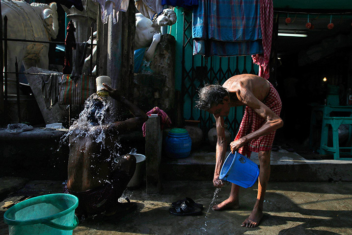 24 hours: Kolkata, India: Indian men use a communal tap to bathe