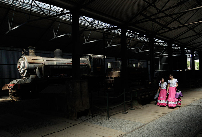 24 hours: Sapucai, Paraguay: Students in traditional dress walk near a steam train