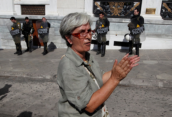 Greece protests: A woman applauds members of Greece's Communist Party