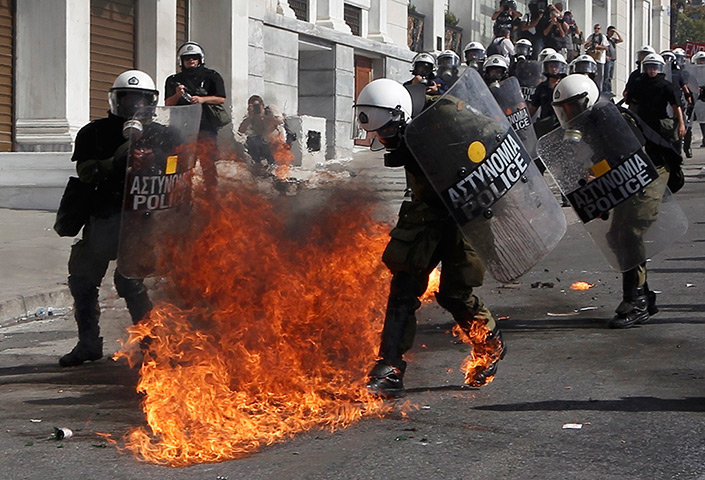 Greece protests: Flames from a molotov cocktail burn on the boots of Greek riot police