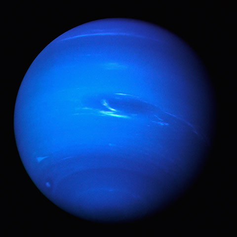 Voyager: Neptune glows a brilliant blue in the night sky seen by Voyager 2