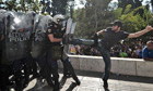 Demonstrator kicks out at riot police in Athens