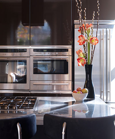 Kitchen with lacquered black units and flowers