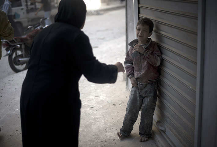 20 Photos: A frightened child stands in the street in Aleppo