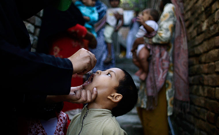 20 Photos: A Pakistani health worker gives a polio vaccine to a boy 