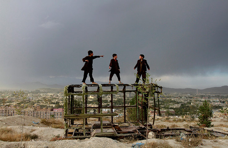 20 Photos: Afghan boys play on a destroyed car on a hilltop in Kabul