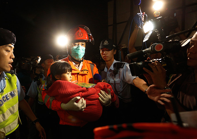 Hong Kong ferry: A young survivor is carried by a rescuer, and taken onto shore 