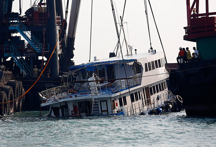 Hong Kong ferry: A half submerged boat is lifted by cranes near Lamma Island