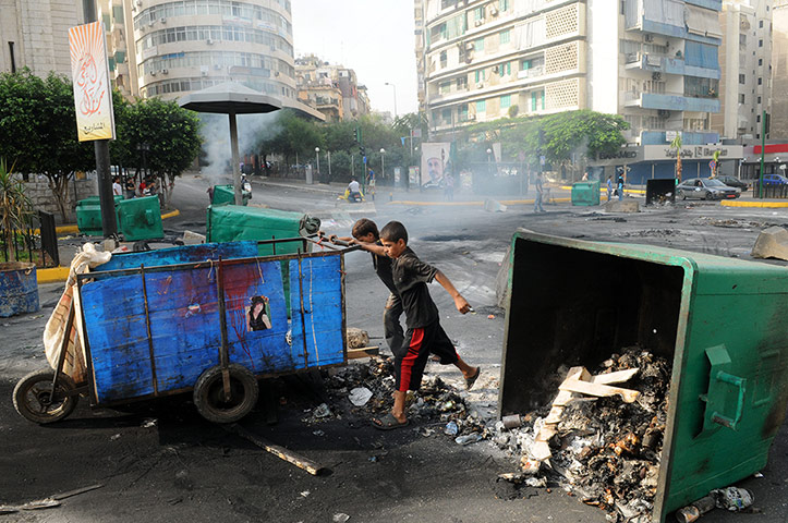 Beirut car Bomb: Lebanese boys push a cart through a road block