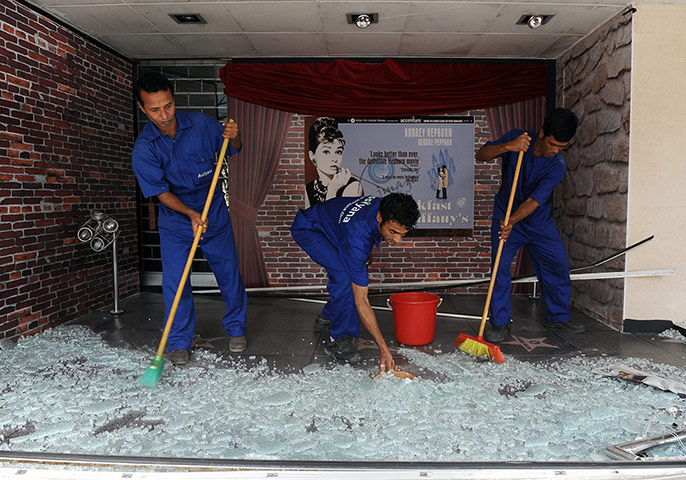 Beirut Car Bomb: Beirut Car Bomb: Workers clean glass near the scene of the explosion