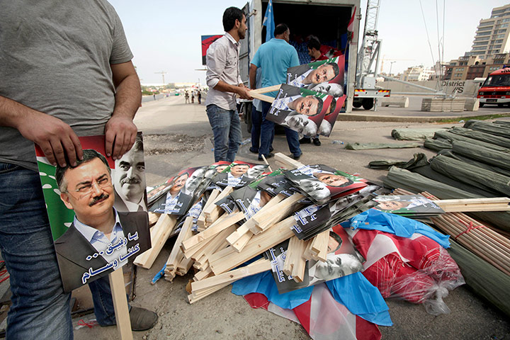 Beirut funeral: Volunteers distribute placards depicting Al- Hassan