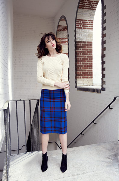 Fashion: Jumpers: Model wears Cream cable knit jumper and black and blue checked skirt