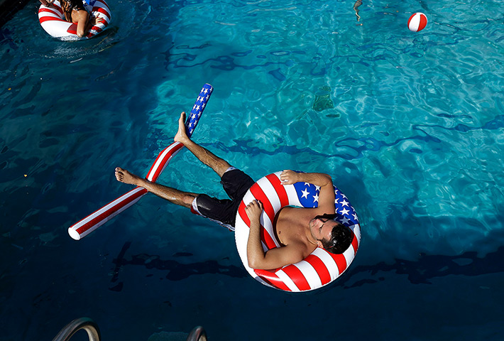 24 hours in pictures: University student Matt Alleva uses patriotic tubes to float