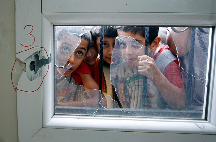 24 hours: Reyhanli district, Turkey: Turkish boys look through a shattered window