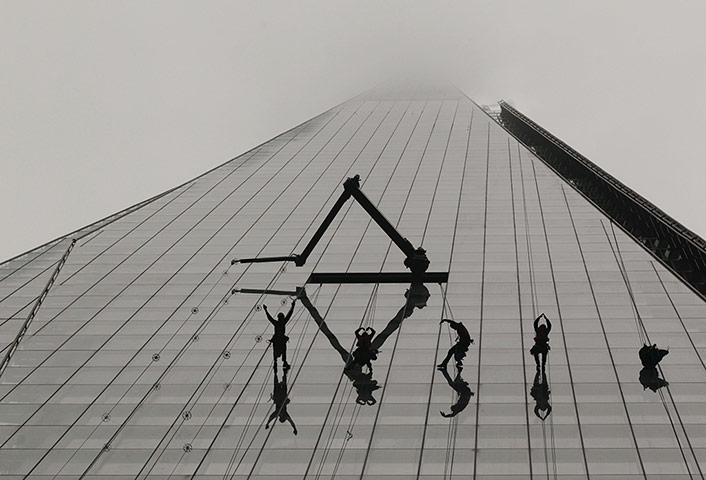 20 Photographs: In London, window cleaners work on the Shard shrouded in fog