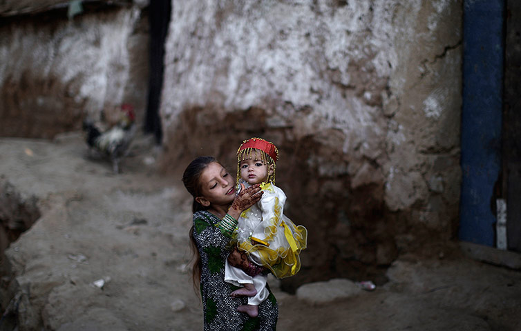 24 hours: fghan refugee girl Parveen Bashir, 6, plays with her sister Shaheen, 1