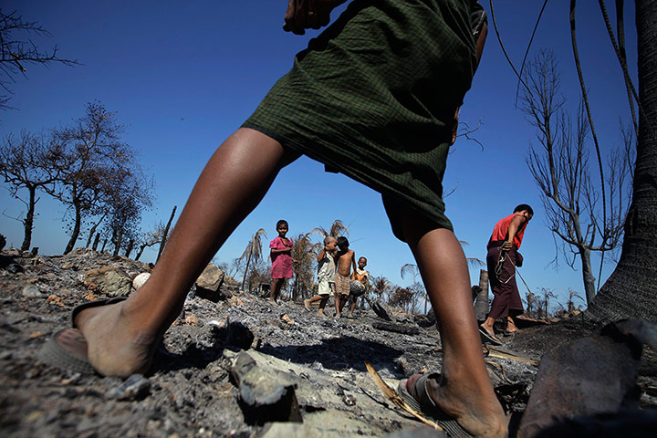 20 Photographs: People collect metal from the rubble of a neighbourhood in Pauktaw
