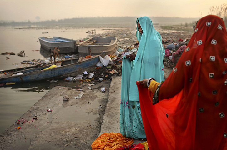 24 hours: New Delhi, India: Hindu devotees put on saris after taking a holy dip