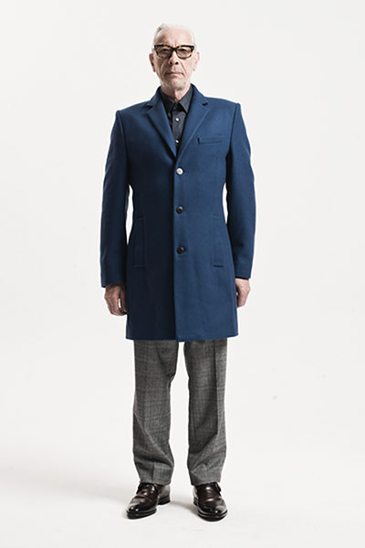 All Ages: Blue: Model wears blue coat with a grey short and grey trousers