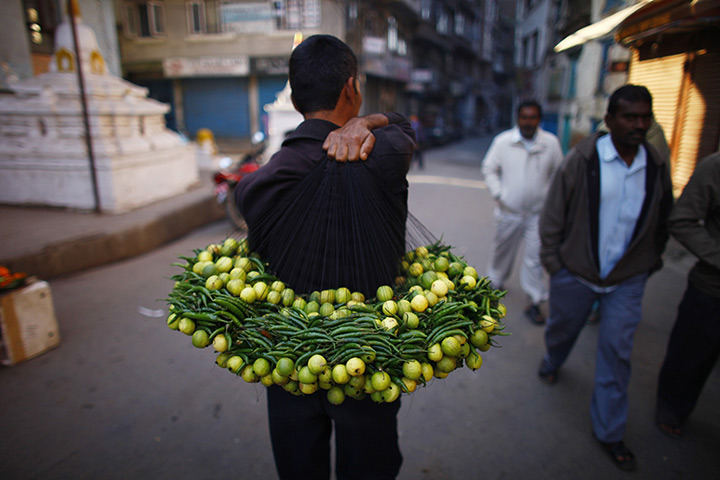 24 hours: Katmandu, Nepal: A man carries strings of lemons and chilis