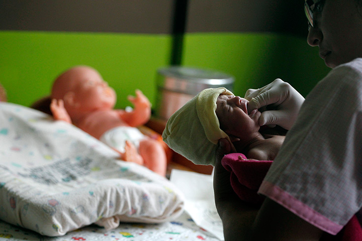 24 hours: Guatemala City, Guatemala: A nurse checks the mouth of a baby 