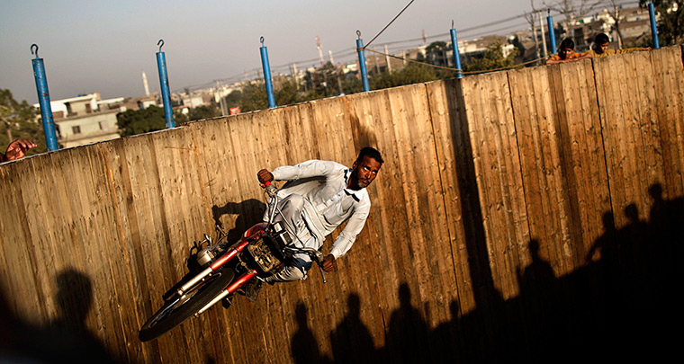 24 hours: Rawalpindi, Pakistan: A man rides his motorcycle around a 'wall of death'