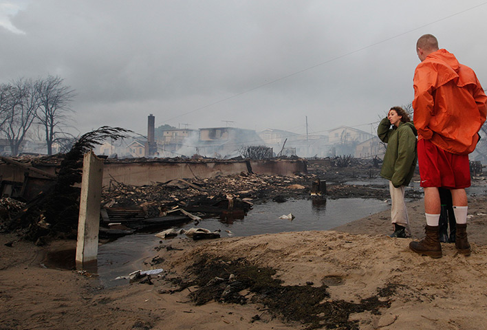 Sandy on east coast: Residents assess the damage caused by a fire at Breezy Point