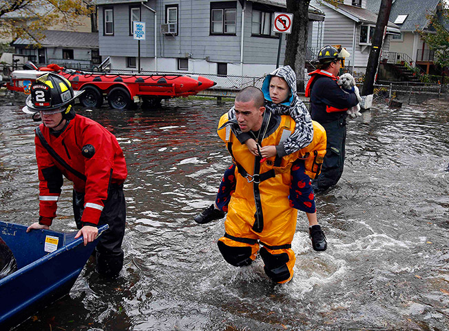 Sandy on east coast: A rescue worker carries a boy in Little Ferry