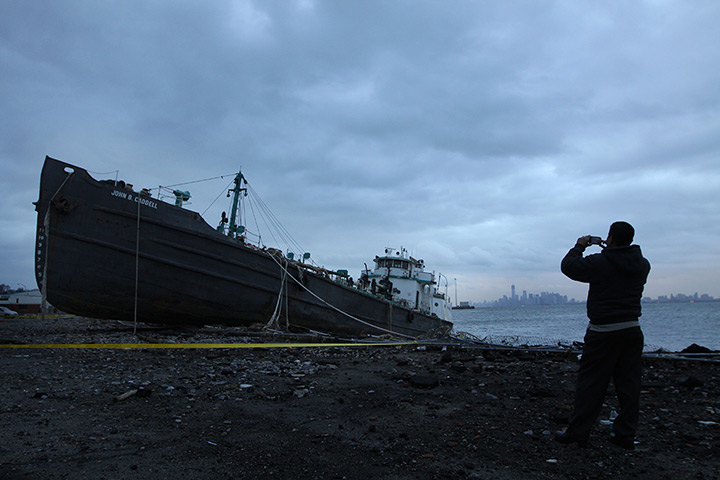 Coastal aftermath: A man takes a picture of the John B Caddell, a 700-ton tanker