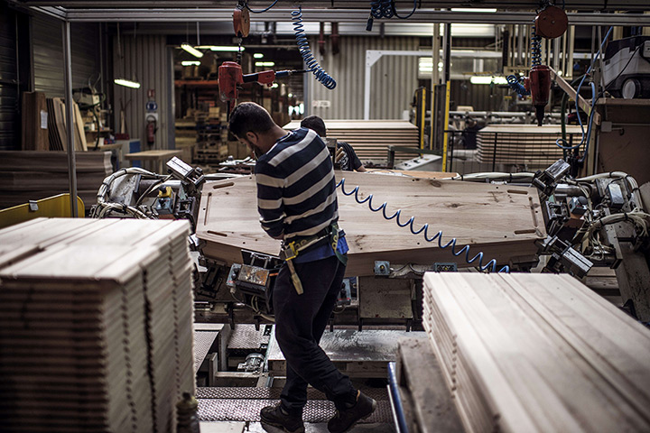 24 hours in pictures: An employee of the OGF company works on a wooden coffin