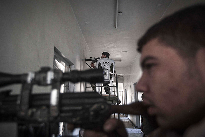 24 hours in pictures: Rebel fighters keep an eye on an enemy position from a school building 