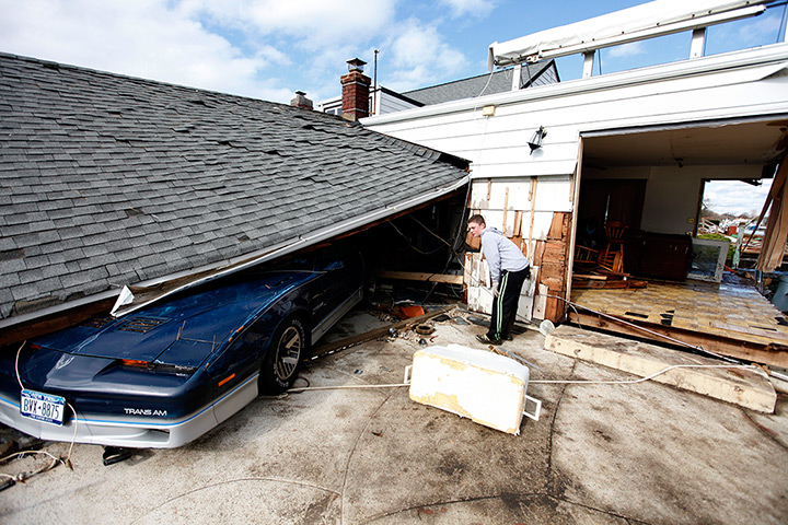 Coastal aftermath update: A boy looks at his grandfather's crushed Trans Am car