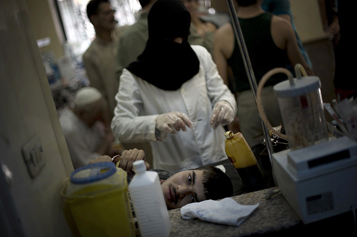 24 hours in pictures: A syrian civilian, wounded from shelling Dar al-Shifa hospital