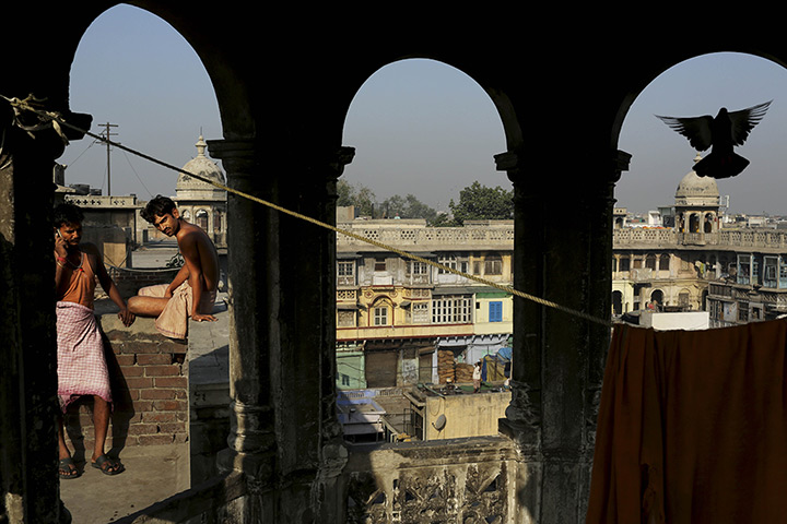 24 hours in pictures: ndian labourers sit on the roof of an old Haveli