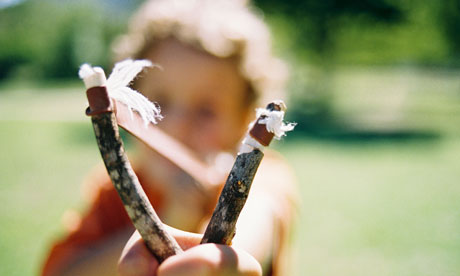 Boy aiming a homemade slingshot
