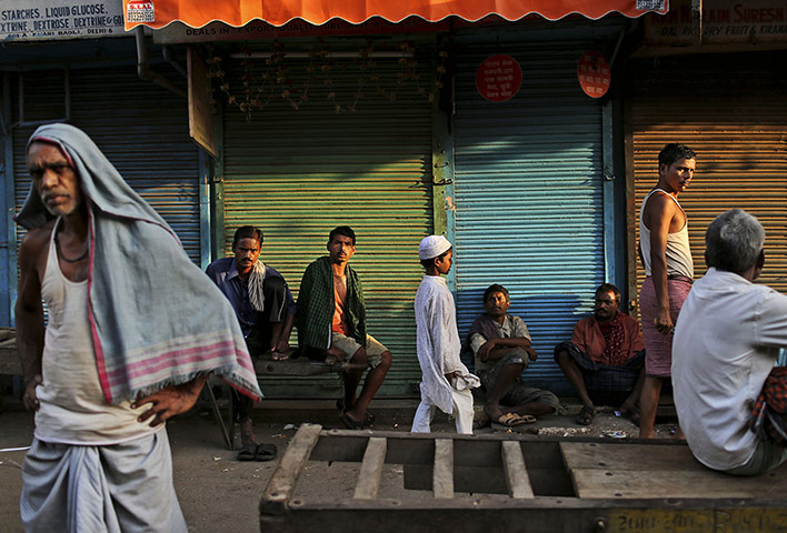 20 Photographs: Indian labourers wait for work in the spice market in New Delhi