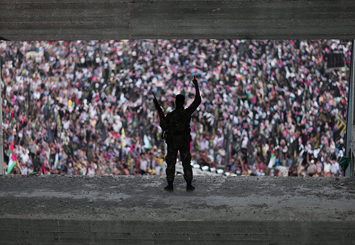 20 Photographs: An Islamic Jihad militant stands guard during a rally marking the anniversary of the movement's founding in Gaza