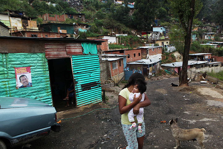 24 hours: A girl carries a baby along a street in Caracas, Venezuela