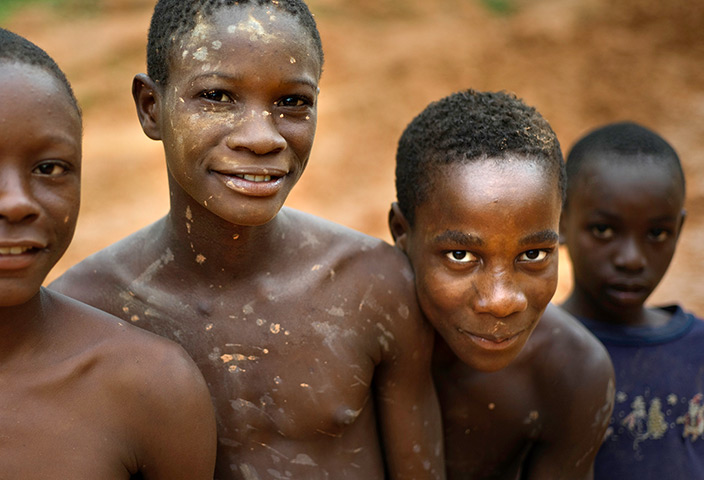 Liberia: Young boys stand on the main road covered in clay in Grand Gedeh county