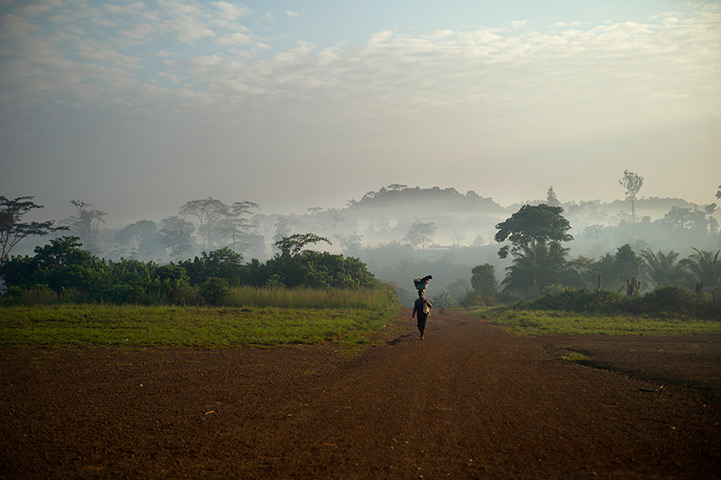 Liberia: A woman carries her washing through Fishtown in early morning light 