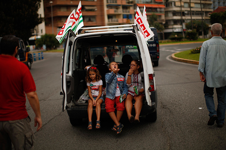 24 hours in pictures: Children eats cheetos at the back of a van during a protest