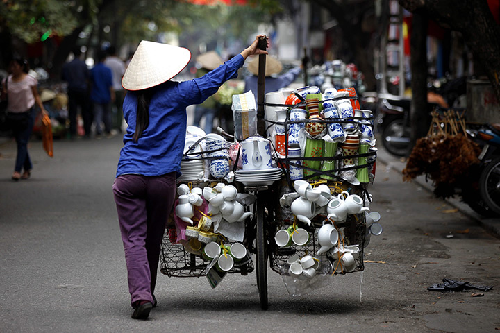 24 hours in pictures: Hanoi, Vietnam: A vendor walks in a street