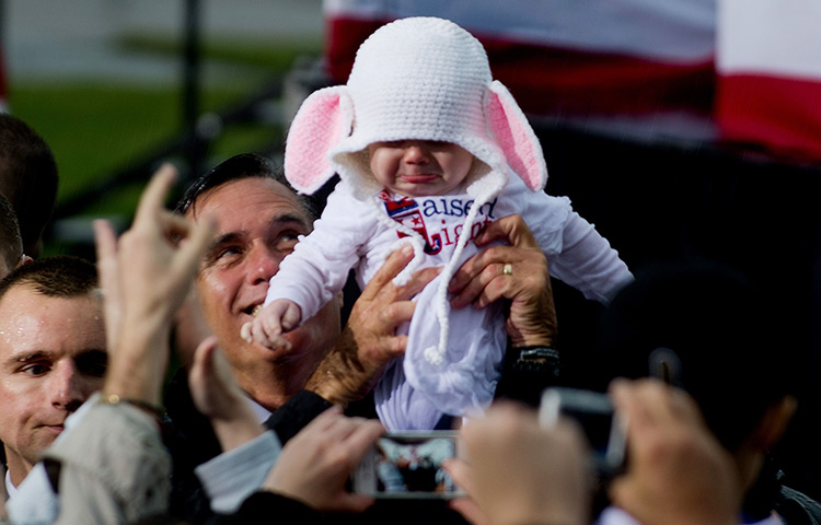 24 hours in pictures: Mitt Romney holds up a baby in a rabbit costume