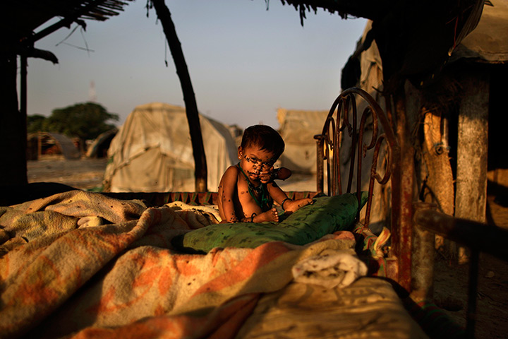 24 hours in pictures: A Pakistani child, her face covered with flies