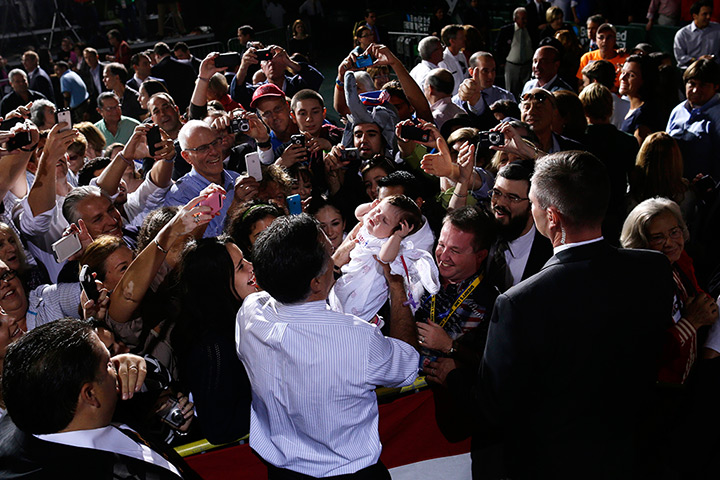 24 hours: Coral Gables, Florida, USA: Mitt Romney picks up a baby