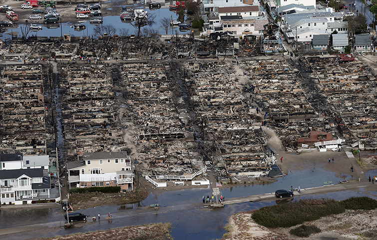 From the agencies: People gather around the remains of burned homes after Superstorm Sandy
