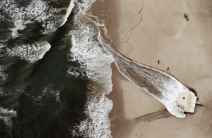 From the agencies: Flood water from Superstorm Sandy is pumped into the ocean from the beach