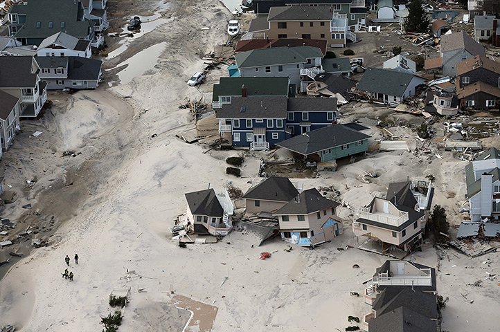 From the agencies: Rescue workers walk past homes wrecked and moved by Superstorm Sandy