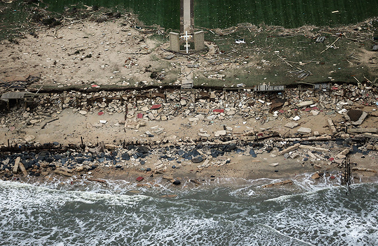 From the agencies: A church cross stands amid wreckage from at the edge of the Atlantic Ocean