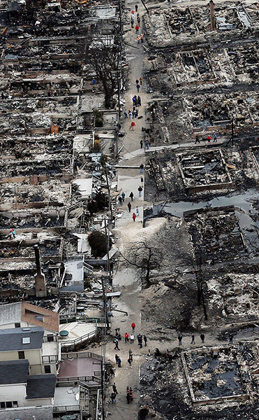 From the agencies: People walk through the remains of burned homes in the Breezy Point, Queens